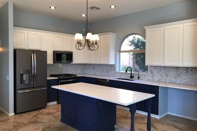 Traditional kitchen in Phoenix with an undermount sink, blue cabinets, quartzite benchtops, white splashback, marble splashback, stainless steel appliances, porcelain floors, with island and beige floor.