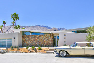 Example of a large minimalist white one-story stone flat roof design in Other