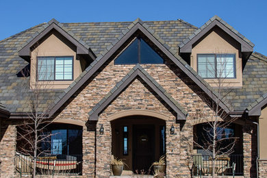 Inspiration for a mid-sized timeless beige two-story stucco house exterior remodel in Denver with a clipped gable roof and a shingle roof