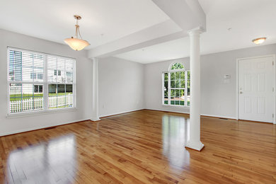 Photo of a small open concept living room in DC Metro with light hardwood floors.