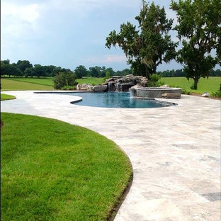他の地域の大きいキドニーシェイプトロピカルスタイルのおしゃれなプール (天然石敷き) の写真