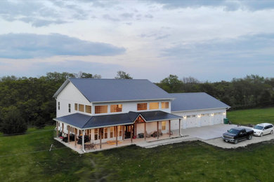 Large cottage white two-story metal house exterior idea in Other with a shed roof, a metal roof and a black roof