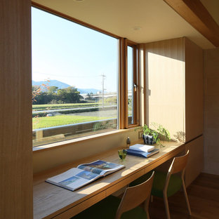 Foto di uno studio etnico con pareti beige, pavimento in legno massello medio, scrivania incassata e pavimento marrone