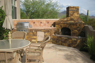 Mid-sized backyard patio in Phoenix with a fire feature, natural stone pavers and no cover.