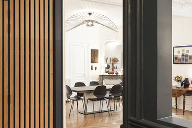 Réalisation d'une entrée avec un mur bleu et parquet clair.
