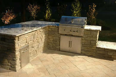 Inspiration for a mid-sized traditional backyard patio in Austin with an outdoor kitchen, natural stone pavers and no cover.