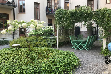 This is an example of a scandinavian patio in Stockholm with gravel and a pergola.