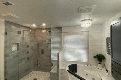 Example of a large minimalist master gray tile and porcelain tile porcelain tile, gray floor, double-sink and wall paneling shower bench design in Cleveland with shaker cabinets, gray cabinets, a bidet, beige walls, an undermount sink, quartzite countertops, a hinged shower door, multicolored countertops and a built-in vanity