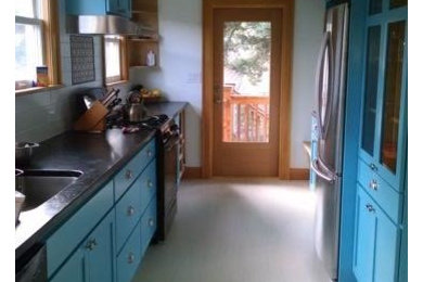Mid-sized transitional galley light wood floor and beige floor enclosed kitchen photo in Seattle with an undermount sink, shaker cabinets, blue cabinets, solid surface countertops and stainless steel appliances
