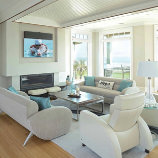 Inredning av ett modernt stort allrum med öppen planlösning, med grå väggar, bambugolv, en standard öppen spis, en spiselkrans i sten och en väggmonterad TV