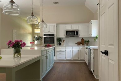 L-shaped kitchen photo in Other with a single-bowl sink, white cabinets, white backsplash, subway tile backsplash, white countertops, quartz countertops, stainless steel appliances and an island