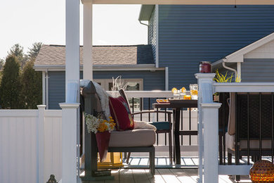 Inspiration for a small modern concrete back porch remodel in Boston with a roof extension