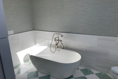 Diseño de cuarto de baño tradicional con bañera exenta, baldosas y/o azulejos grises, paredes grises, suelo de mármol, suelo blanco y papel pintado