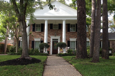 Inspiration for a mid-sized timeless red two-story brick exterior home remodel in Houston with a shingle roof