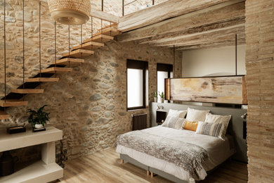 Foto de dormitorio principal rural grande con suelo de madera en tonos medios y techo inclinado