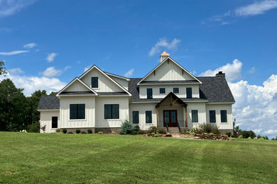 Large farmhouse white two-story concrete fiberboard and board and batten house exterior photo in Raleigh