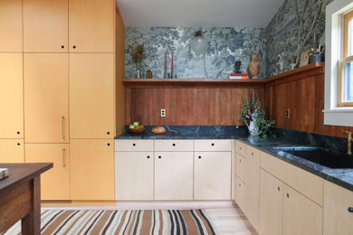 Example of a mid-sized danish l-shaped light wood floor eat-in kitchen design in Boston with an undermount sink, flat-panel cabinets, orange cabinets, marble countertops, brown backsplash, wood backsplash, paneled appliances, an island and green countertops