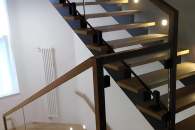 Свежая идея для дизайна: огромная угловая лестница с деревянными ступенями и деревянными перилами - отличное фото интерьера