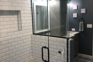 Large eclectic master white tile and ceramic tile vinyl floor and beige floor corner shower photo in Other with shaker cabinets, gray cabinets, a one-piece toilet, blue walls, a drop-in sink, granite countertops, a hinged shower door and white countertops
