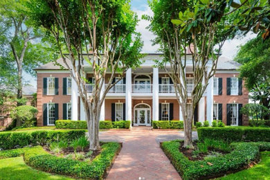 Huge elegant white two-story brick house exterior photo in Houston with a hip roof, a shingle roof and a gray roof