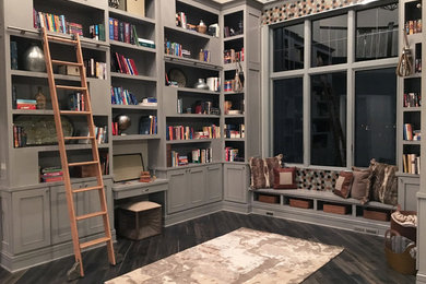 Design ideas for an expansive transitional home office in Milwaukee with a library, dark hardwood floors, beige walls, no fireplace, a built-in desk and grey floor.