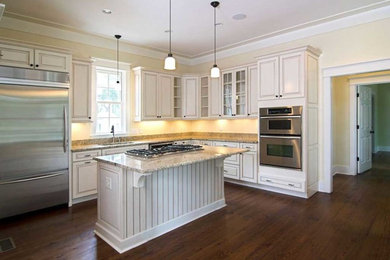 Inspiration for a mid-sized contemporary u-shaped dark wood floor and brown floor open concept kitchen remodel in Toronto with an undermount sink, raised-panel cabinets, white cabinets, granite countertops, stainless steel appliances, an island and multicolored countertops