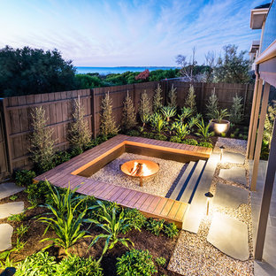Mid-sized beach style backyard full sun garden in Melbourne with a fire feature and gravel for winter.