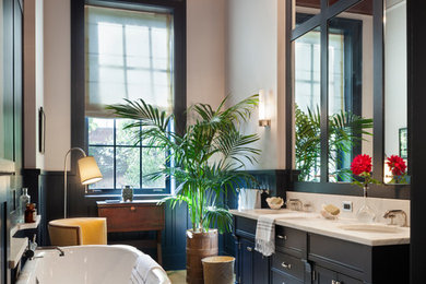 Mid-sized traditional master bathroom in New York with recessed-panel cabinets, grey cabinets, a claw-foot tub, grey walls, light hardwood floors, an undermount sink, marble benchtops, brown floor and white benchtops.