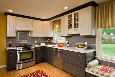Kitchen - traditional kitchen idea in Boston with raised-panel cabinets, gray backsplash and stainless steel appliances