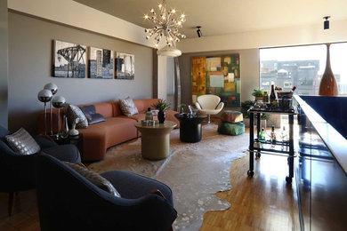 Example of a large trendy open concept medium tone wood floor and brown floor living room design in Montreal with a bar, gray walls, no fireplace and no tv