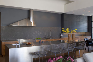 Inspiration for a contemporary kitchen remodel in Phoenix with flat-panel cabinets, stainless steel appliances, black backsplash, stone slab backsplash, stainless steel countertops, an integrated sink and black cabinets