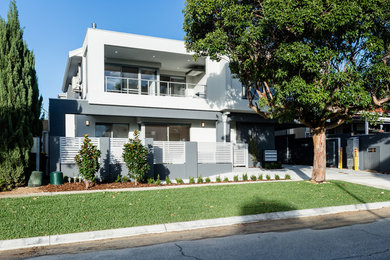 Photo of a mid-sized contemporary two-storey white exterior in Perth.