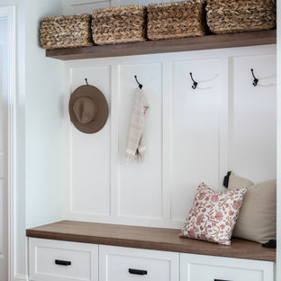 Diseño de puerta principal boiserie, de estilo de casa de campo, pequeña, con paredes blancas, suelo de madera oscura, puerta simple, puerta de madera en tonos medios, suelo marrón y boiserie