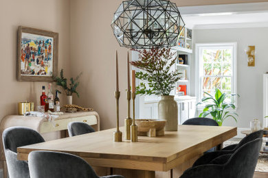 This is an example of a mid-sized eclectic dining room in San Francisco with pink walls, medium hardwood floors and brown floor.