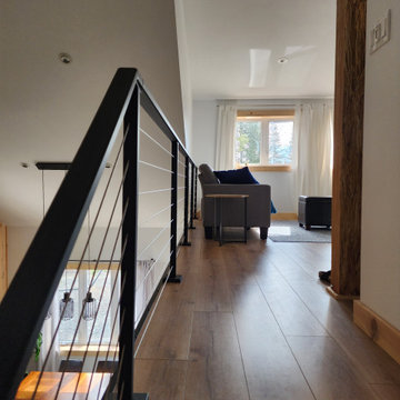 Indoor black metal post cable railing project in Saguenay, Quebec