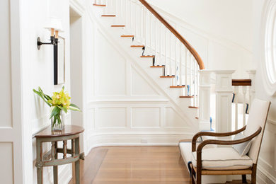 This is an example of a mid-sized traditional foyer in New York with white walls and medium hardwood floors.