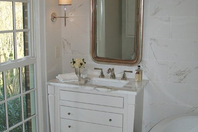 Freestanding bathtub - small transitional 3/4 gray tile, white tile and porcelain tile freestanding bathtub idea in Charlotte with furniture-like cabinets, white cabinets, white walls, an undermount sink and marble countertops