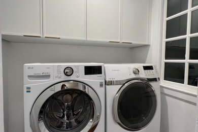 Inspiration for a mid-sized contemporary single-wall medium tone wood floor dedicated laundry room remodel in San Francisco with shaker cabinets, white cabinets, white walls and a side-by-side washer/dryer