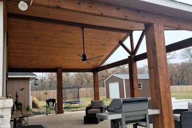 Large mountain style back porch idea in Austin with a roof extension