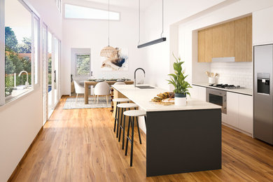 Large contemporary kitchen in Sydney with an undermount sink, light wood cabinets, solid surface benchtops, white splashback, ceramic splashback, stainless steel appliances, medium hardwood floors, with island and multi-coloured floor.