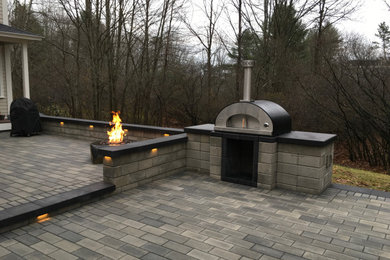 Example of a large trendy backyard concrete paver patio kitchen design in Portland Maine