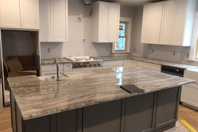 Mid-sized minimalist l-shaped eat-in kitchen photo in New York with an island and granite countertops