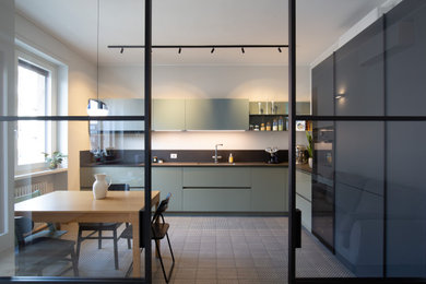 Idee per una cucina a L minimal chiusa e di medie dimensioni con lavello sottopiano, ante lisce, ante verdi, top in quarzo composito, paraspruzzi in gres porcellanato, elettrodomestici neri, pavimento con piastrelle in ceramica, nessuna isola, pavimento grigio e top grigio