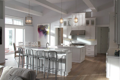 Open concept kitchen - large transitional l-shaped gray floor and light wood floor open concept kitchen idea in Jacksonville with shaker cabinets, white cabinets, subway tile backsplash, stainless steel appliances, two islands and a farmhouse sink