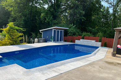 Inspiration for a large tropical backyard concrete and custom-shaped pool fountain remodel in DC Metro