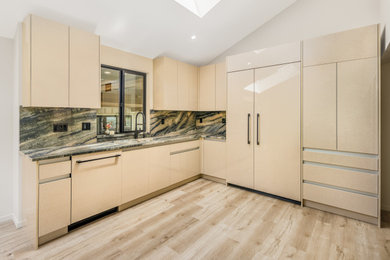 Large minimalist u-shaped eat-in kitchen photo in Vancouver with flat-panel cabinets and an island