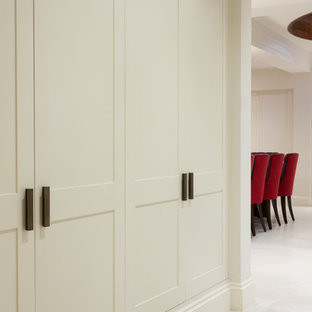 Photo of a large eclectic basement in London with beige walls, ceramic floors, no fireplace and white floor.