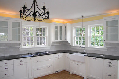Elegant l-shaped kitchen photo in Portland with a farmhouse sink, granite countertops, white backsplash and subway tile backsplash
