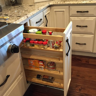 Geräumige Klassische Küche in U-Form mit Vorratsschrank, Unterbauwaschbecken, profilierten Schrankfronten, weißen Schränken, Granit-Arbeitsplatte, Küchenrückwand in Weiß, Küchengeräten aus Edelstahl und zwei Kücheninseln in Sonstige