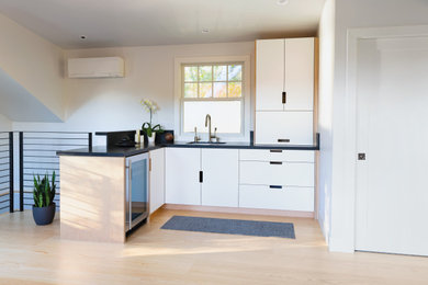 Example of a small minimalist l-shaped eat-in kitchen design in San Francisco with flat-panel cabinets, white cabinets, quartzite countertops, no island and black countertops